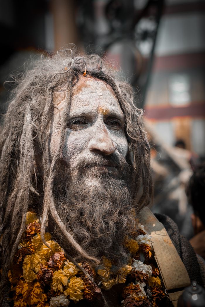 Services A spiritual Sadhu adorned with face paint and garlands in Varanasi, India.