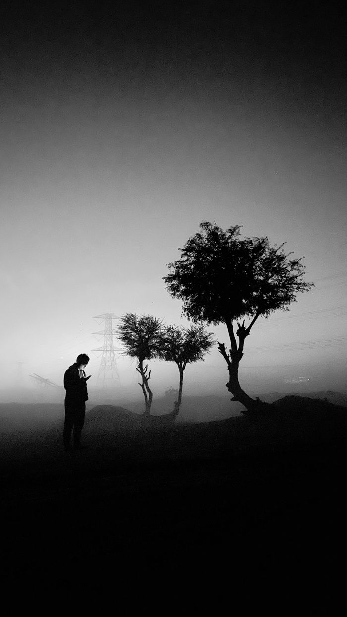 The Art of Drawing Readers In: Your attractive post title goes here A moody black and white silhouette of a man in a foggy evening landscape, Dubai.